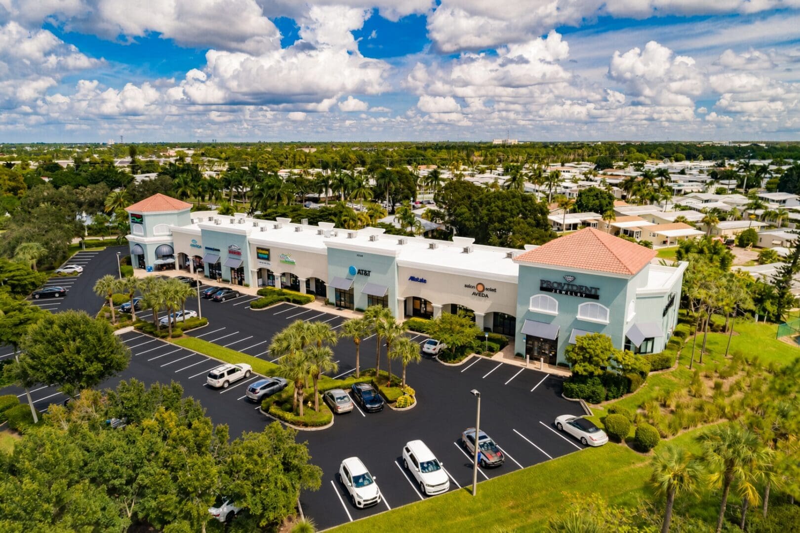 Aerial view of North Collier Village commercial center with white membrane and flat gray roofs, Bonita Springs